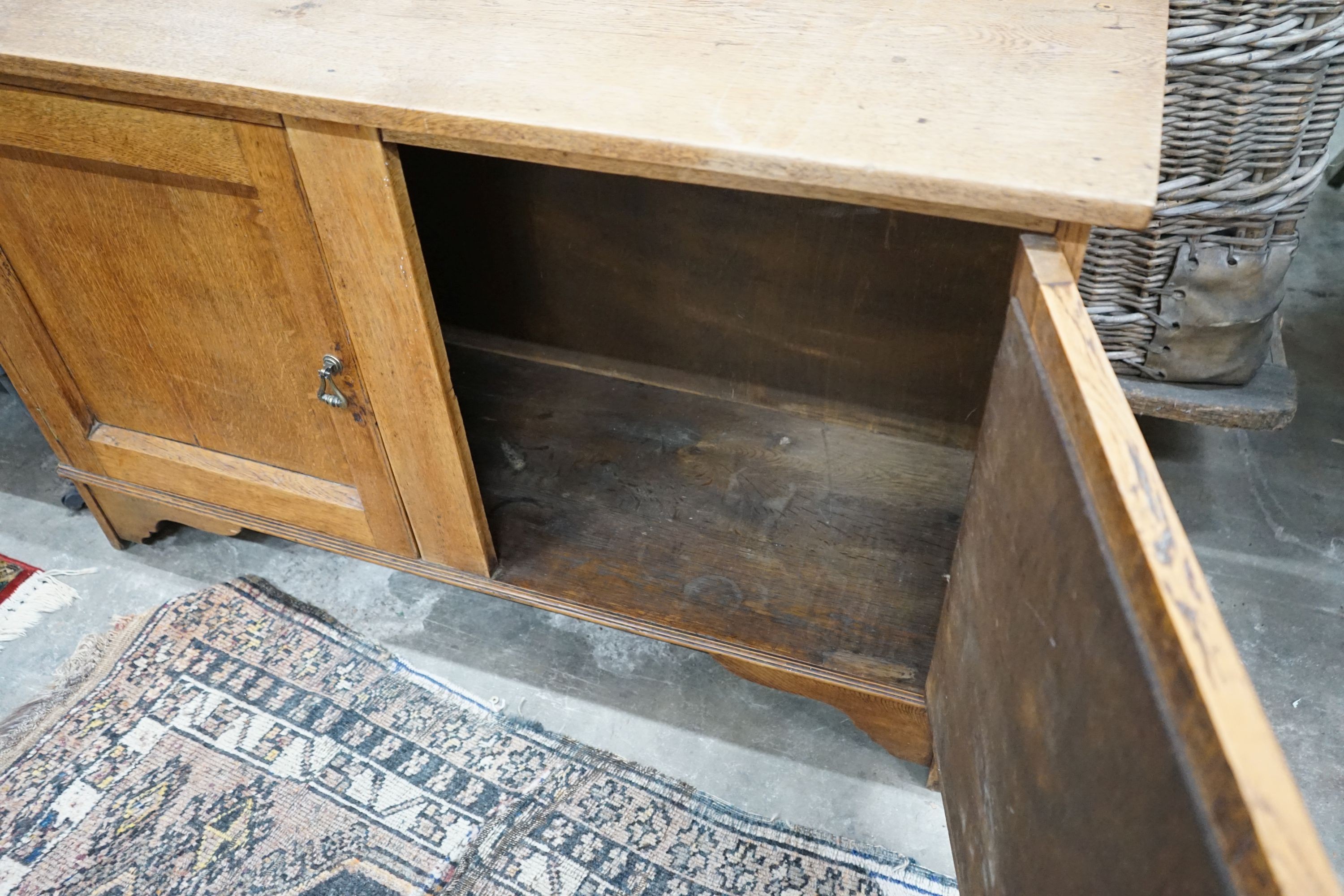 A 1920's two door oak low cabinet, width 120cm, depth 39cm, height 76cm